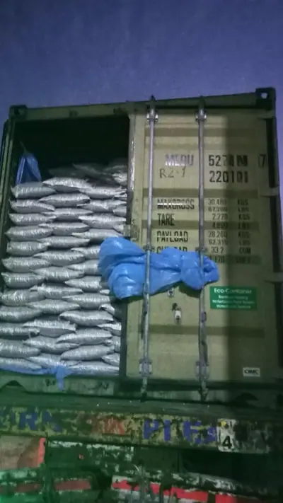 20 ft container of white bags loaded at night