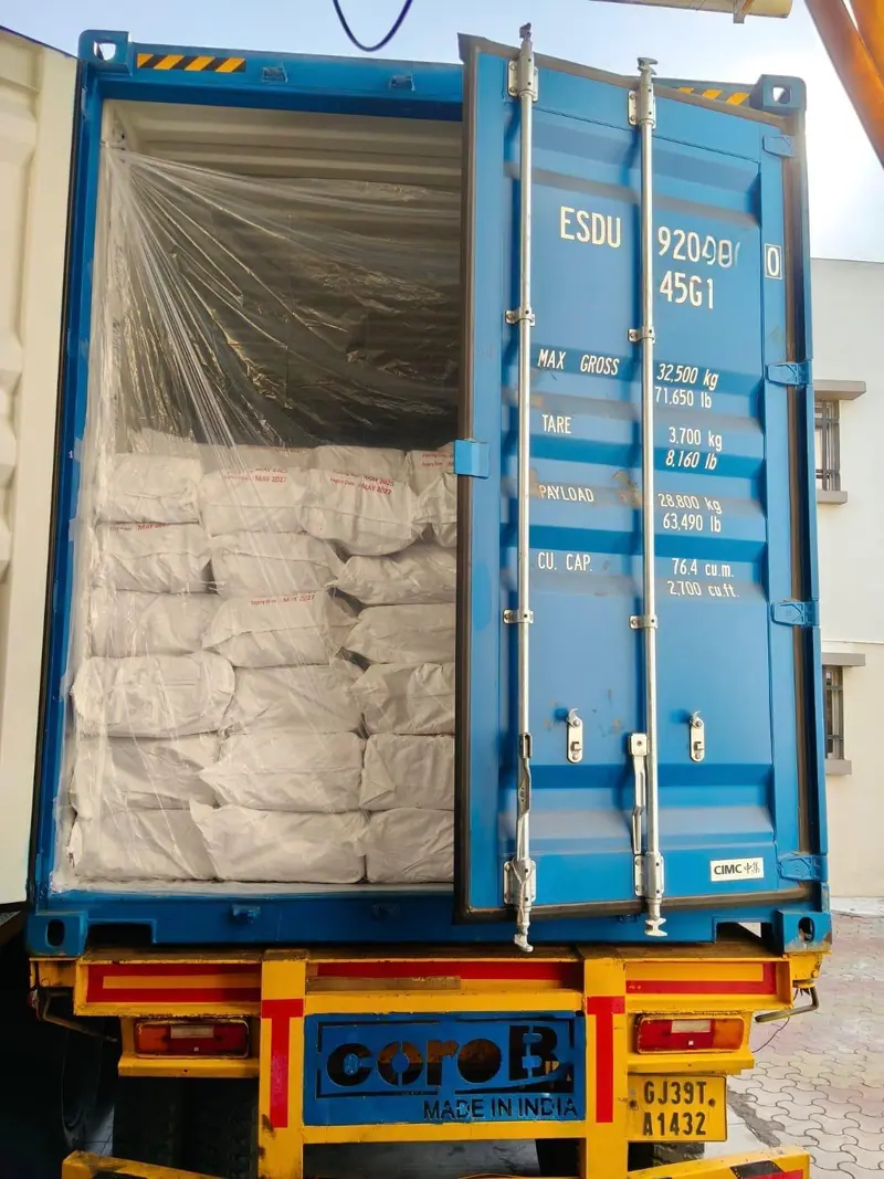 Beige PP bags behind a plastic liner in a 40 ft high-cube container