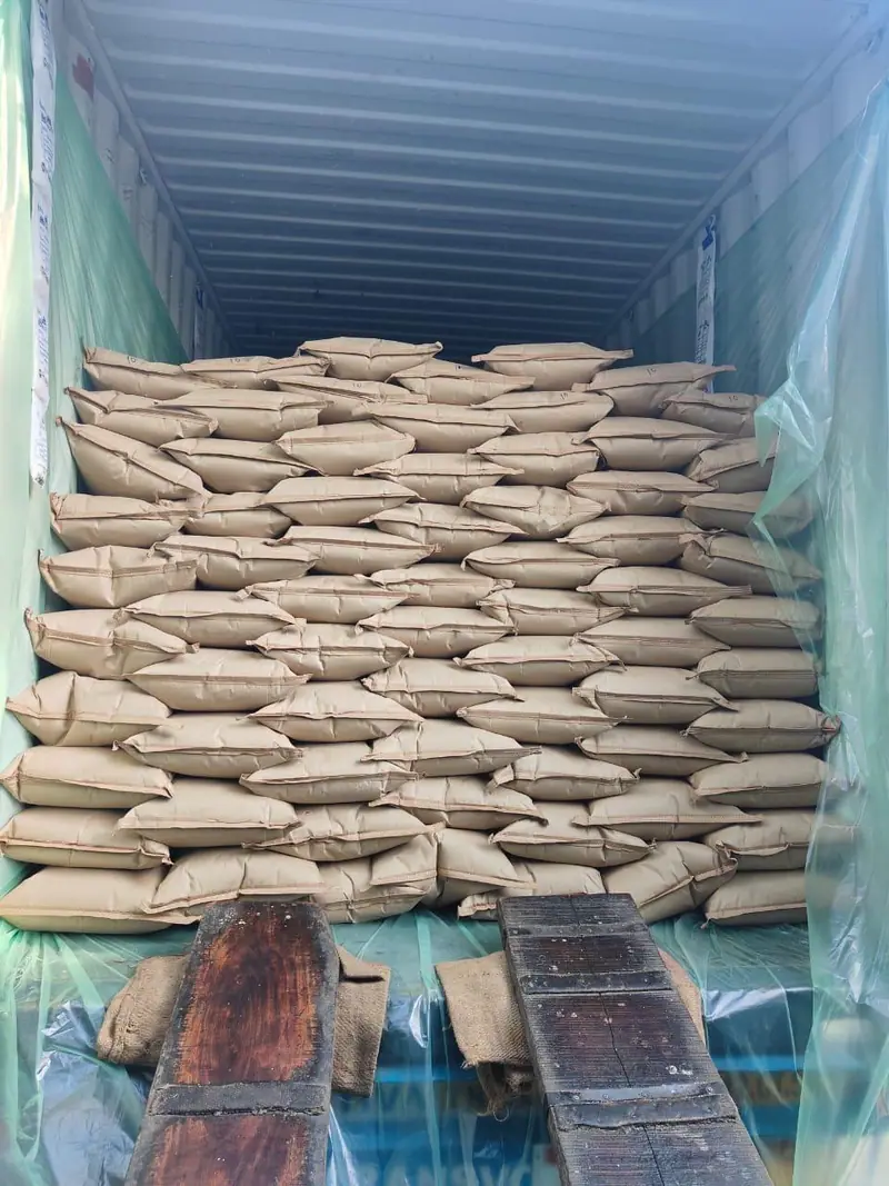 Jute bags stacked inside a lined container, seen from the loading ramp