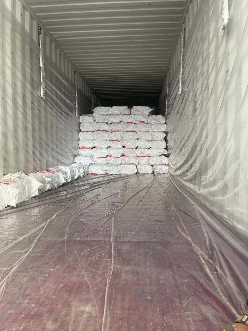 White bags being loaded at the far end of a lined container