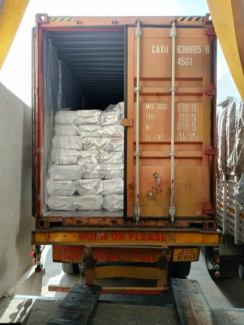 White PP bags being loaded into a 40 ft high-cube container at the dock