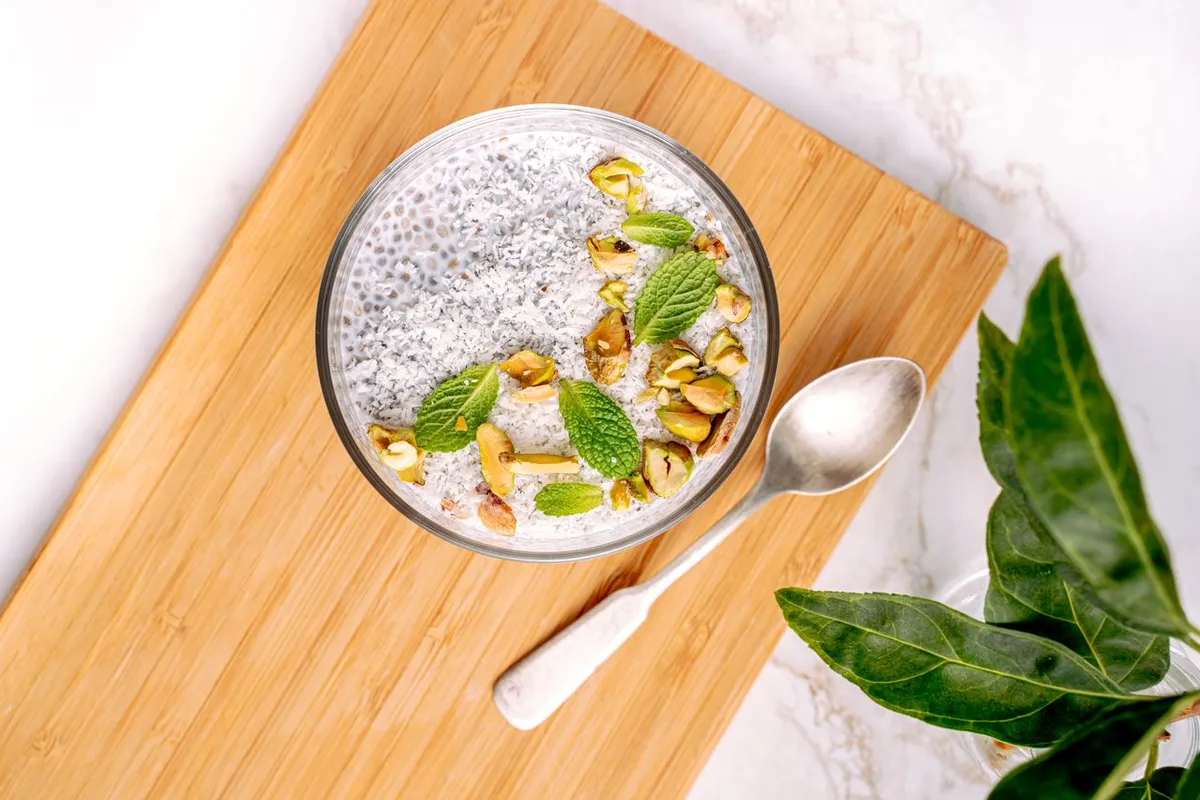 Chia seed pudding in a bowl topped with nuts and mint