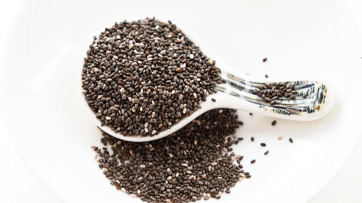 Black chia seeds in a dish, showing the difference between chia seeds and basil seeds