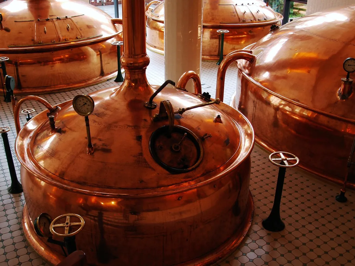 Copper brewhouse vessels where corn grits for brewing are cooked and mashed