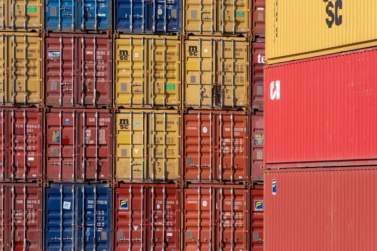 Stacked shipping containers at a port awaiting export clearance