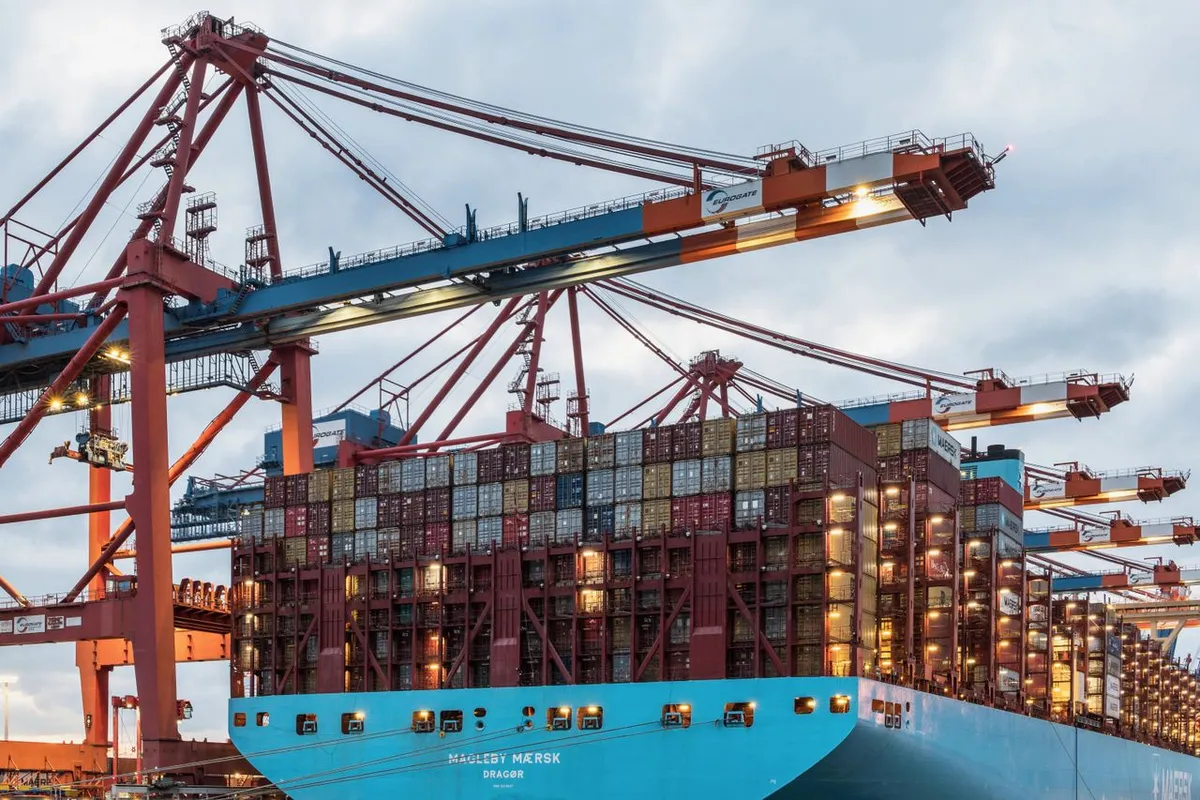Container ship at port cranes, where freight and port charges add to FOB price