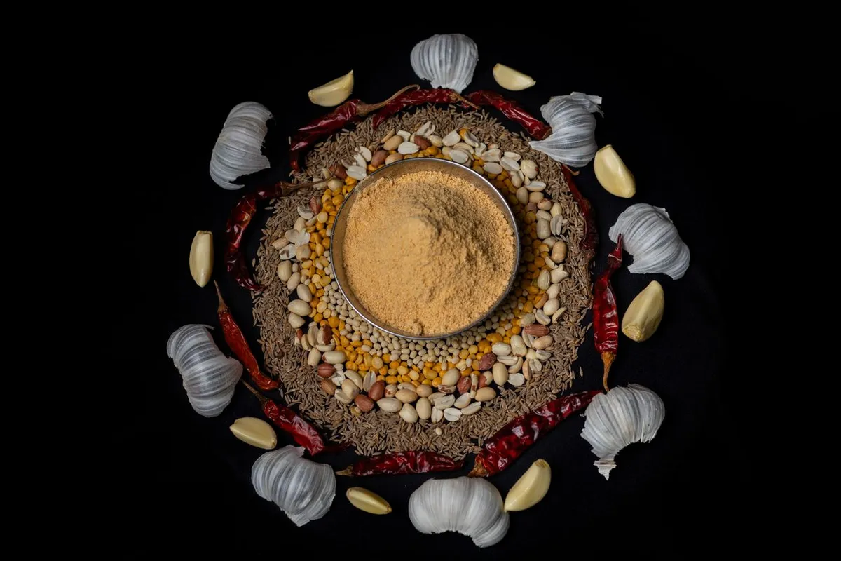 Bowl of garlic powder surrounded by garlic cloves and spices