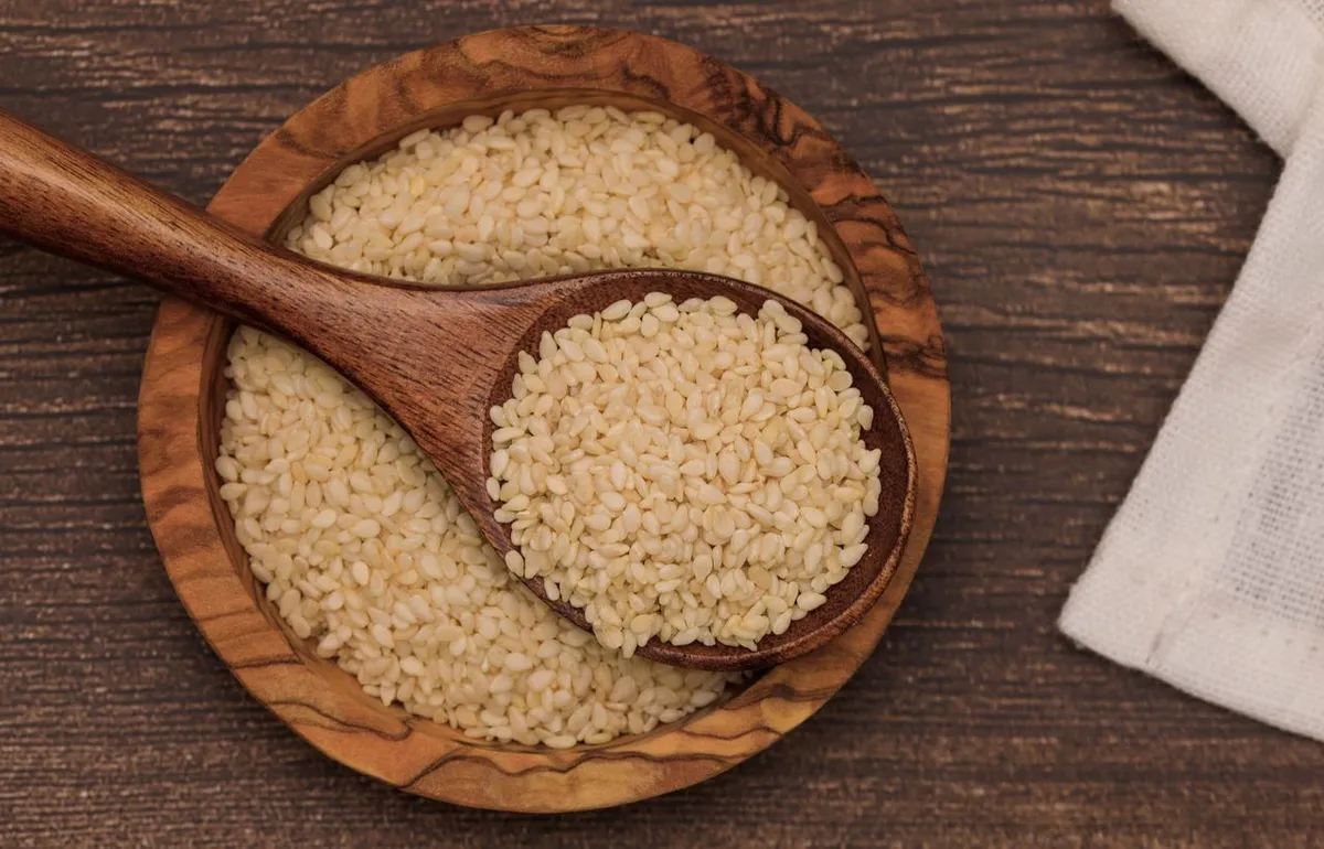 Natural sesame seeds in a wooden bowl, rich in calcium and minerals