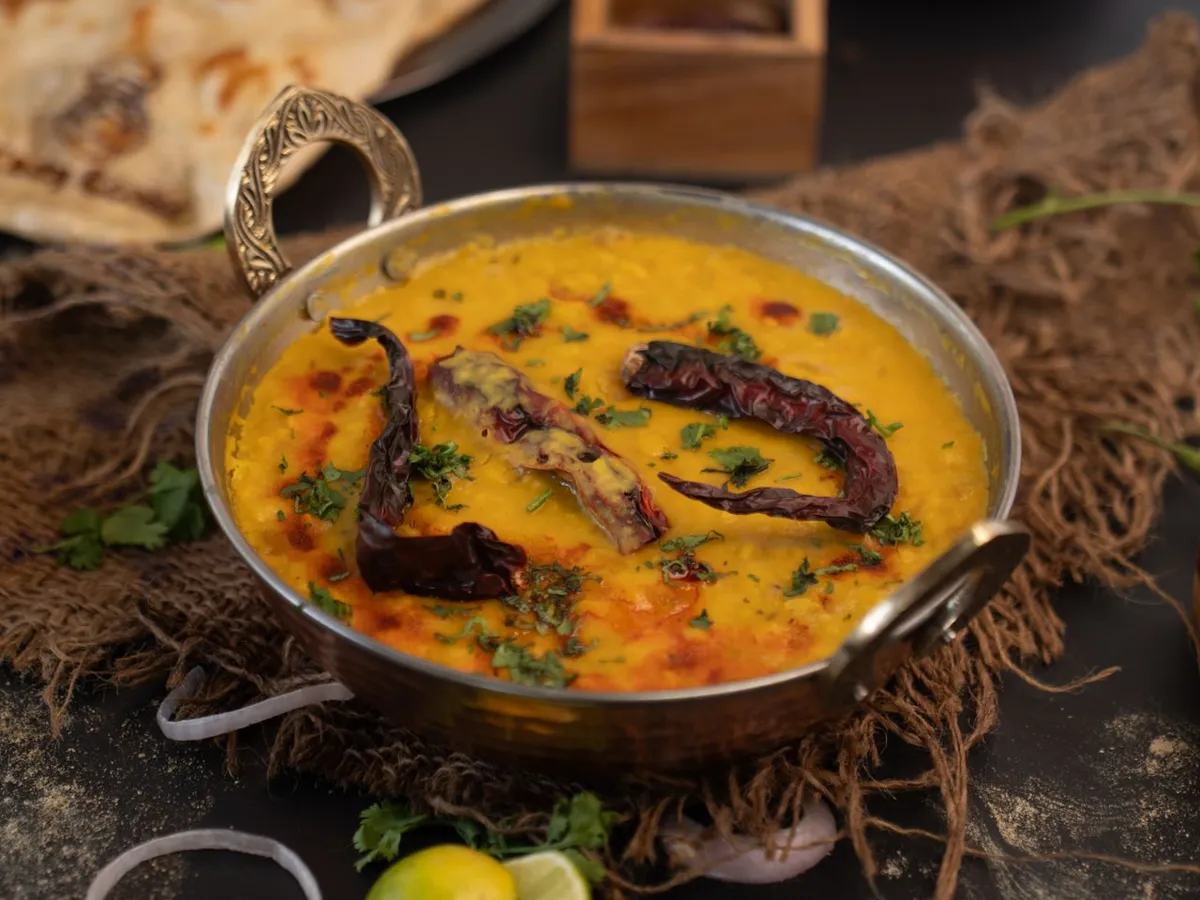 Cooked toor dal tadka served in a pan, a common use of pigeon peas